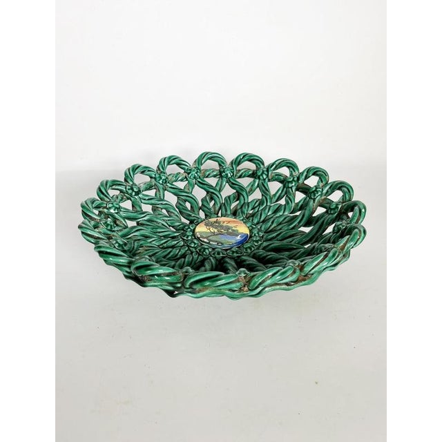 An elegant glazed ceramic fruit basket featuring an openwork structure of twisted motifs that create a delicate, plant-...