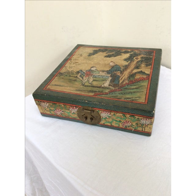 Vivid hand painted pigskin leather small trunk or box with bronze closure and blue fabric lining. The top has two figures...