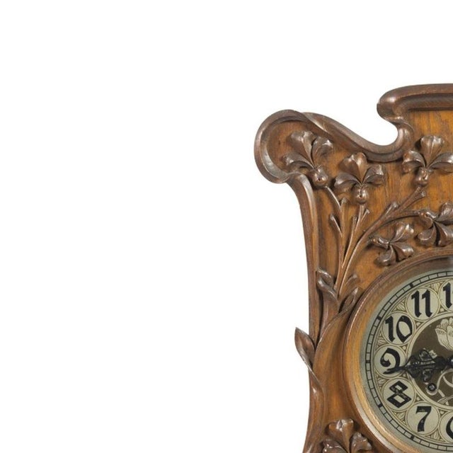Wall clock - 19th century (92 cm). Made of carved oak wood, decorated with vegetal motifs. Dial with Arabic numerals....