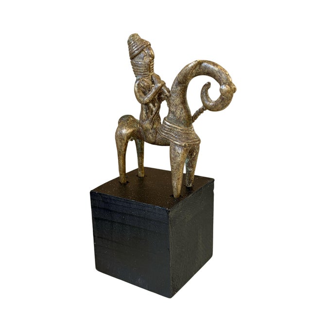 This vintage Dogon bronze equestrian figure on a black wooden stand is a mrammuo—a traditional gold weight—measuring 5.25"...