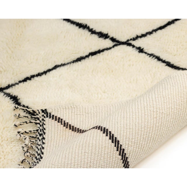 Minimalist hand-knotted wool rug, showcasing Ivory and Midnight Black in a classic diamond design, perfect for adding...