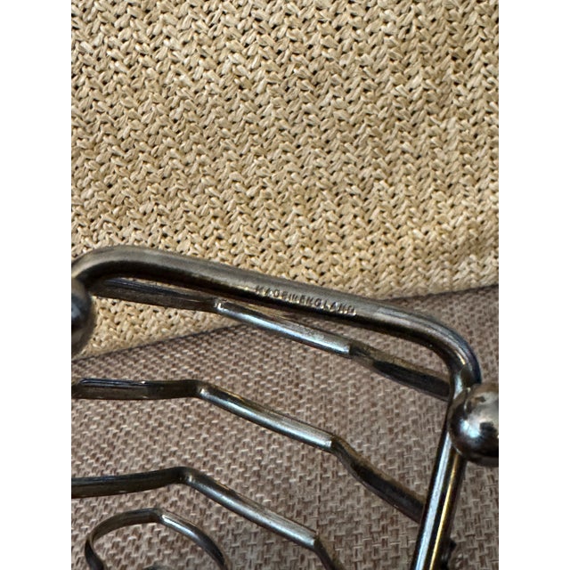 Classic English silver-plated toast rack, marked Made in England, featuring an elegant arched loop handle and evenly...