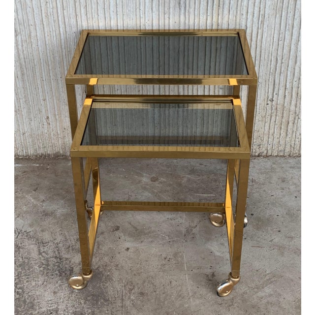 About Pair of Italians nesting tables, brass in original patina and glasses in perfect conditions, they are on wheels....