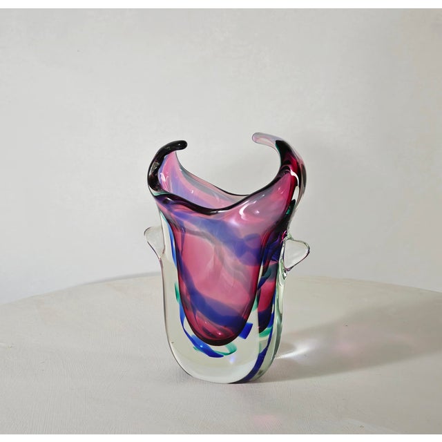 Murano production circa 1970. Thick vase in colorless, lilac, and blue sommerso glass, decorated with a ribbon-like...