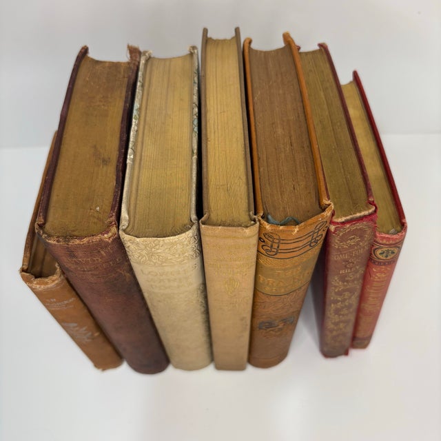 Set of 7 vintage and antique books in neutral browns and tans with metallic accents on the spines. Varying subject matters...