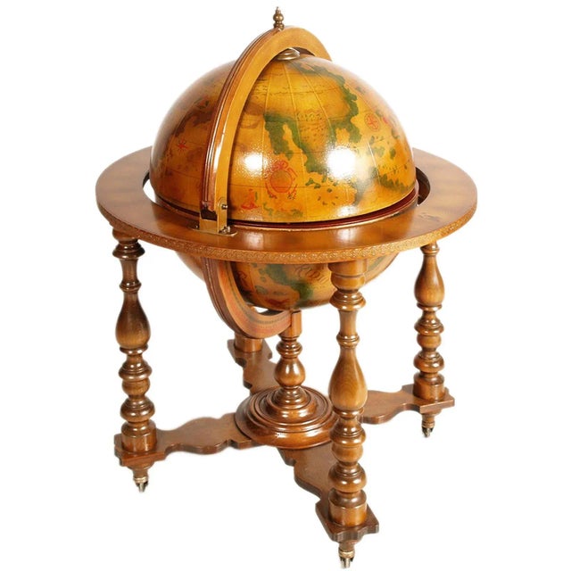Italian 20th century on decorated world map cocktail bar cart. The globe rotates and is supported by a four-legged...
