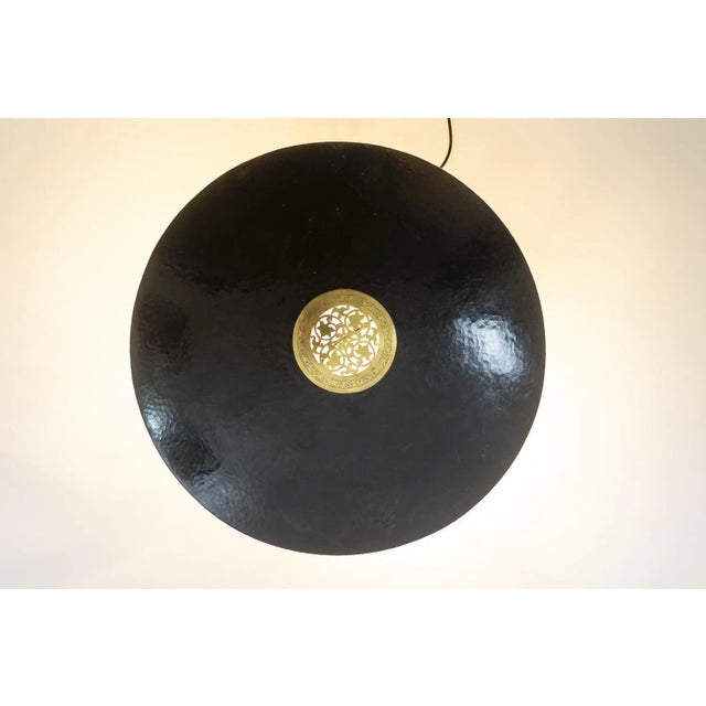 Circular wall light in hammered brass with a bronze and gilt patina, in the Moorish style. Work realized in the 20th...