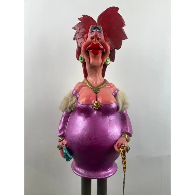 This striking approximately 5-foot-tall metal sculpture depicts a whimsical, fashionably dressed lady rendered in a...