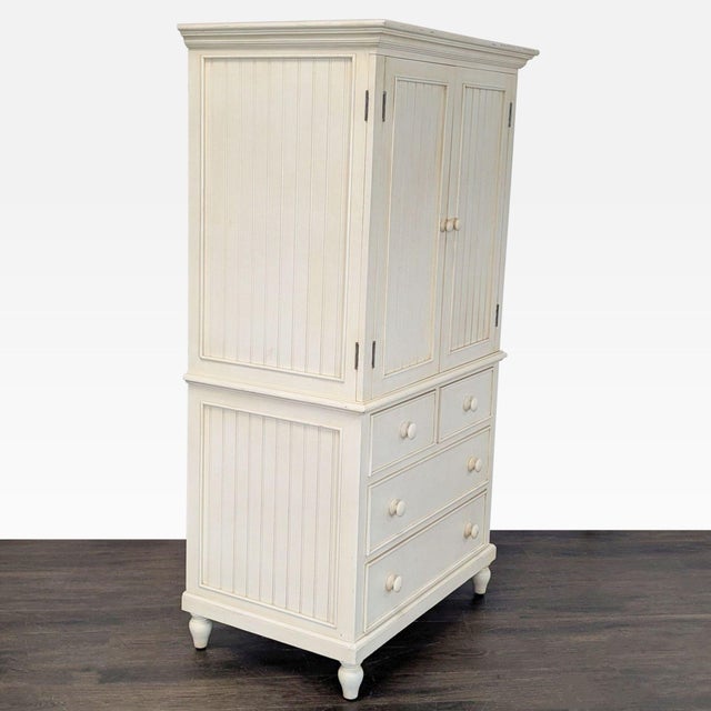 This ivory hutch & armoire features a spacious cabinet with double doors and a shelf, as well as four drawers for extra...