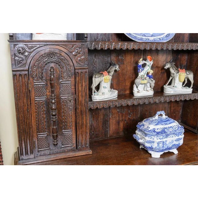 Most unusual antique English carved oak dresser with rack, shelves and cupboards on a three drawer base with cabriole legs.