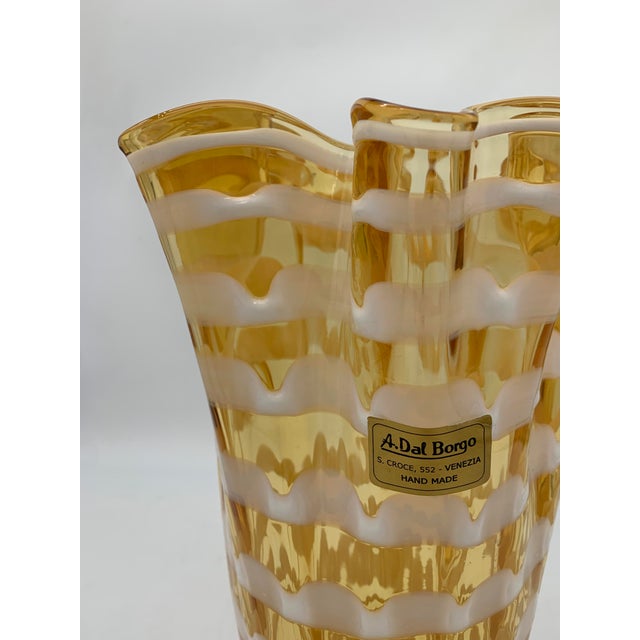 Blown artistic glass vase with a slender shape, slightly flared at the top, featuring the characteristic irregular...