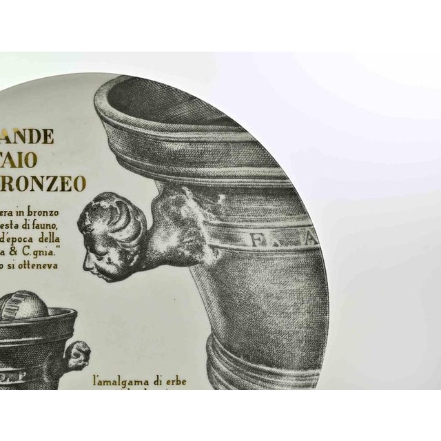 Grande Mortaio Bronzeo is an elegant silk-screened porcelain plate, designed by Piero Fornasetti for Martini & Rossi in...