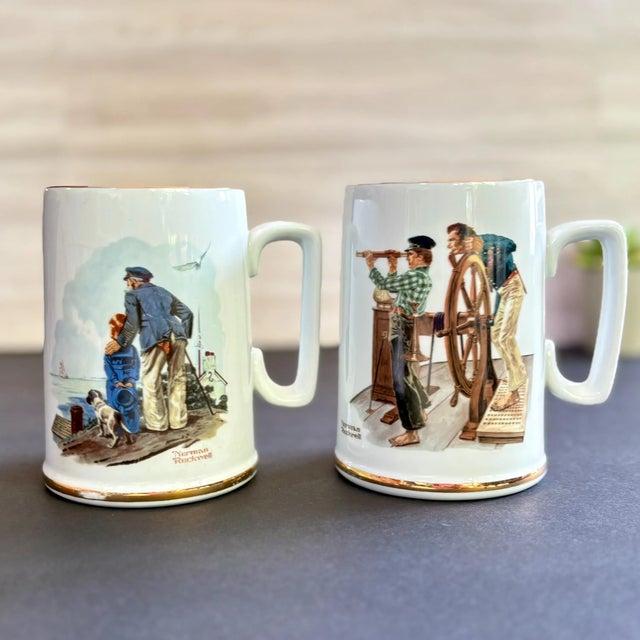 Pair of vintage Norman Rockwell ceramic mugs from the Norman Rockwell Museum Collection—“River Pilot” and “Looking Out to...