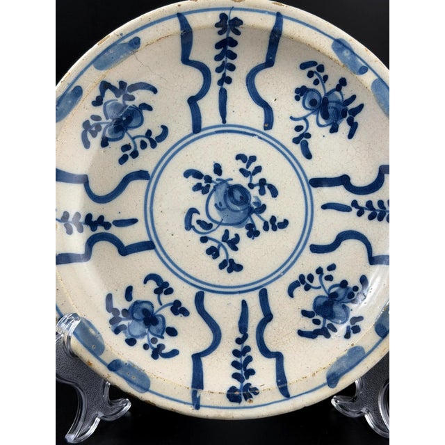 A charming Catalan tin-glazed ceramic plate featuring a classic radial “medallion” composition, characteristic of...