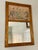 A small gilt wall mirror w/ a hand-colored fashion plate in the upper register. The frame is finely patterned with...