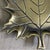 Gold brass vintage metal maple leaf trinket dish, frequently used as a decorative catch-all tray for jewelry, coins, or...
