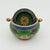 A jewel-like mid-century cloisonné ashtray with an unexpectedly clever bit of engineering. The rounded green enamel body...