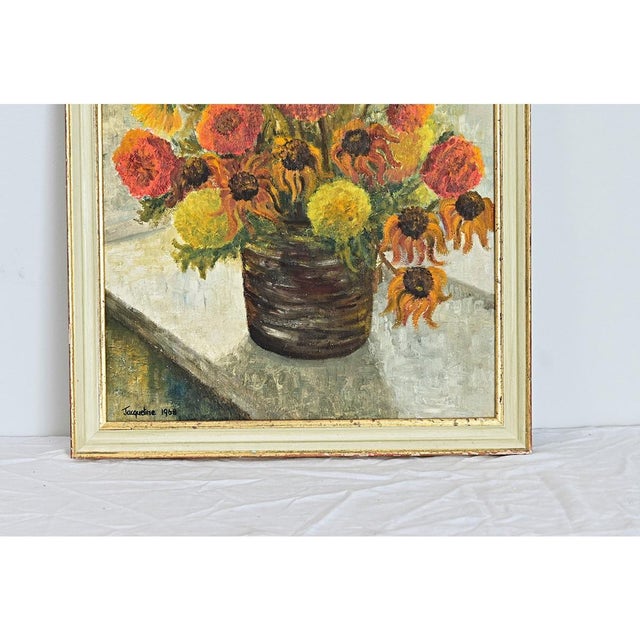 A mid-20th century oil on canvas floral still life painting from England, in vintage frame of similar age and condition....