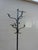 An elegant freestanding wrought iron hall stand dating to around 1900, featuring gracefully curved coat hooks, an...