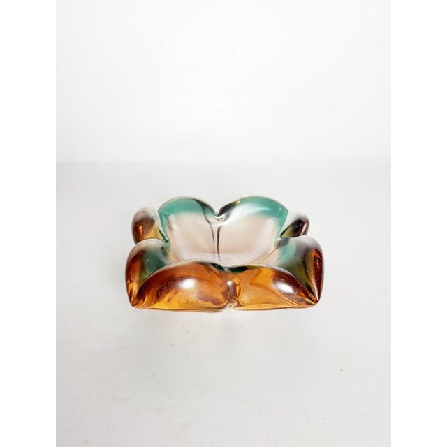 Beautiful Italian flower-shaped colored glass ashtray dating from the 1960s, featuring an elegant sculptural design and a...