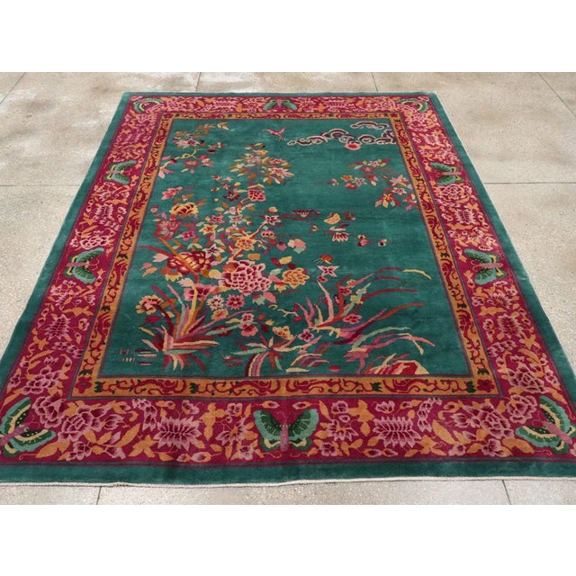 This mid-20th century Chinese Art Deco rug, features a striking emerald green field adorned with an intricate floral...