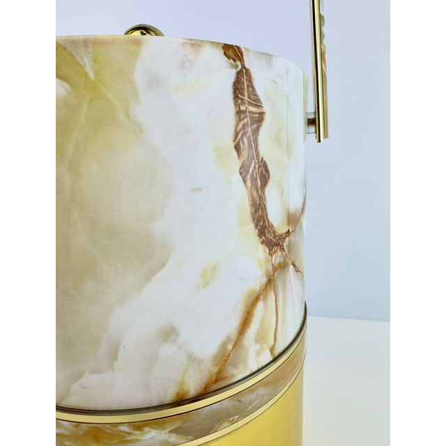 A stylish vintage ice bucket by Elegance by Kraftware, featuring a creamy faux onyx finish with dramatic caramel-brown...