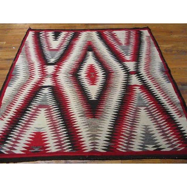 Unusually square, this is a vibrating double X and lozenge pattern, all nested and jagged lines, detailed in red, ecru,...