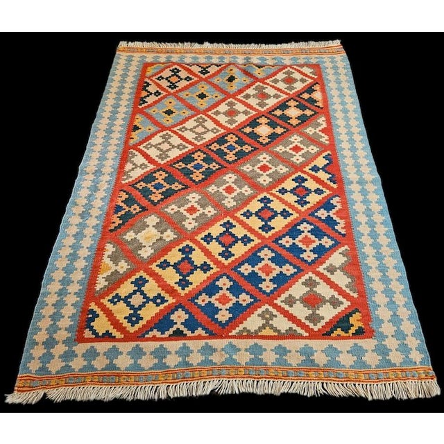 A stunning handcrafted Afghan kilim featuring an elegant geometric diamond design enclosing traditional tribal-inspired...