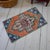 This vintage Oushak mat radiates warmth with its sun-faded terracotta field and striking deep blue accents. Its low-...