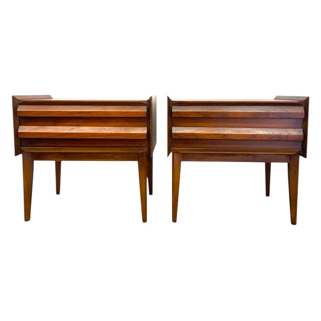 Crafted in warm-toned walnut wood, this pair of mid-century modern nightstands by Lane Furniture features dramatic...