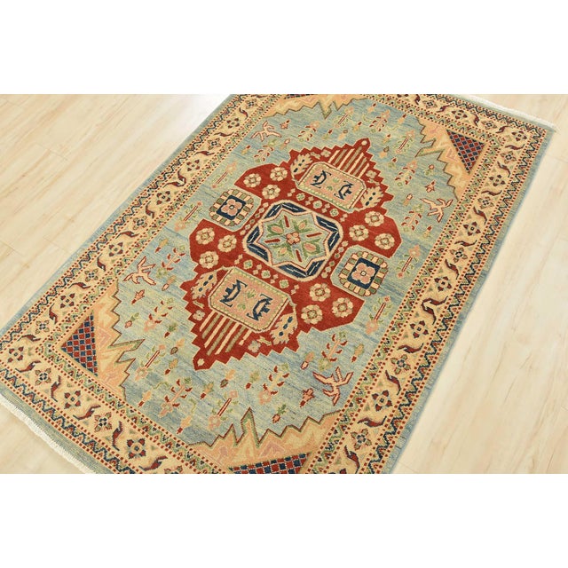 This traditional tribal geometric Caucasian Kazak rug is hand-knotted with an all-wool pile on a cotton foundation. This...