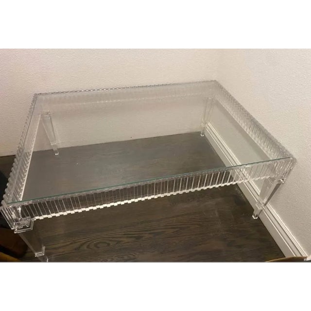 This handcrafted acrylic and glass table is a classically shaped cocktail table with tall, tapered, clear acrylic legs...