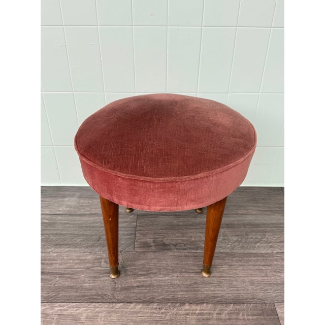 Vintage pouf made in Italy in the 1950s. Small ottoman with a wooden frame and legs, and a padded seat upholstered in pink...