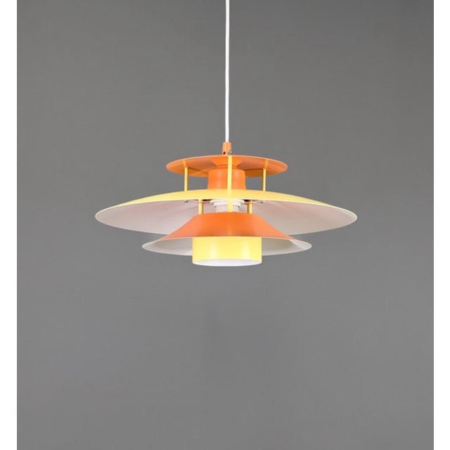 A beautifully balanced Danish pendant lamp from the 1970s, executed in warm yellow and orange lacquered metal. with its...