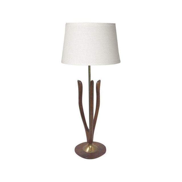 Mid-Century sculptural walnut lamp in a triple wishbone shape standing on a flat circular base. This 1950's era lamp looks...