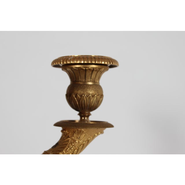 Antique tall empire style 3-armed floor candelabra made of a combination of gilded and brown-patinated metal and bronze....