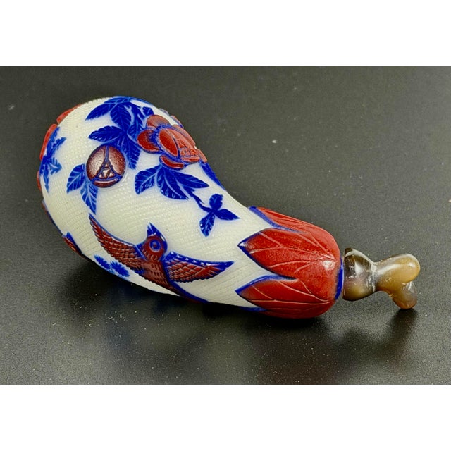This is a finely detailed and unique Chinese Peking glass snuff bottle shaped like an eggplant. This piece features deep...