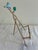 A charming vintage cast iron easel display stand featuring a hand-painted blue bird perched on a decorative branch with a...