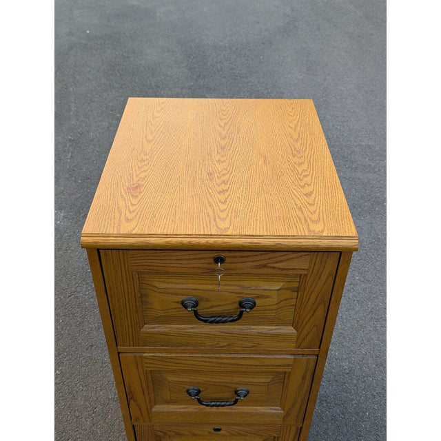 Elevate your workspace with this handsome oak filing cabinet, executed in a traditional design. The piece is defined by...