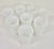 Set of eight vintage white milk glass goblets featuring a raised textured pattern, flared rims, and pedestal bases. The...