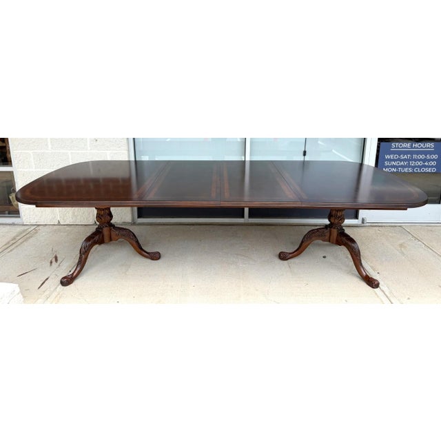 This Drexel Heritage dining table features a rich mahogany finish with contrasting banded inlay that highlights its...