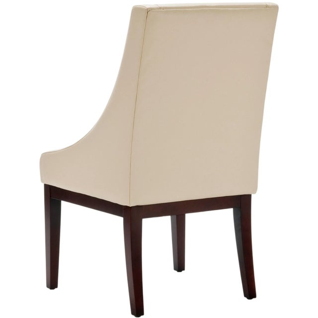The simpli of lines and gently sloping arms of the cream-colored leather upholstered Sloping chair, with legs in cherry...