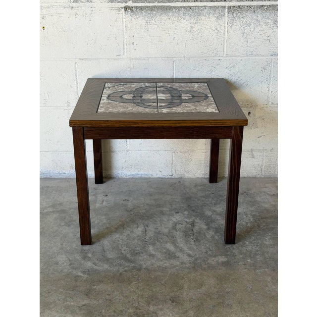 This square coffee table features a robust, clean-lined silhouette with an inset top. The surface showcases beautifully...