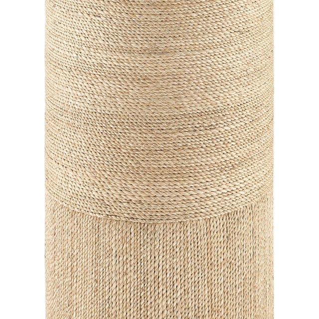 Wrapped in natural rope, the Macati Rope Accent Table is made of wood and topped with a disc of glass. The artistry...