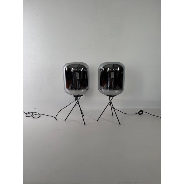 Striking pair of designer floor lamps with a modern, minimalist form. The shades are made of smoked glass with a mirrored...