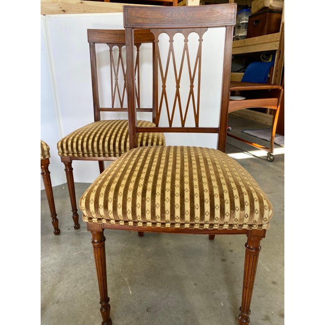Elegant set of four Edwardian side chairs in fruitwood with delicate inlay on the back rail and on the turned legs. The...