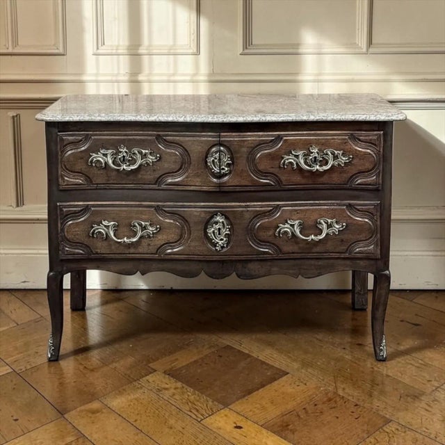 18th Century French Louis XV Walnut Marble Top Commode combines elegance, premier craftsmanship and timeless hand-selected...