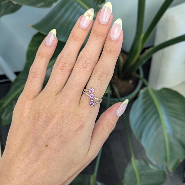 Bold 2.1ct purple sapphire radiating rich color with 4mm presence and brilliance, set in a modern three-stone wrap design....