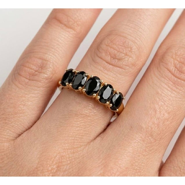 Bold, sophisticated, and timeless, this striking ring features a row of deep, captivating Black Onyx gemstones, designed...