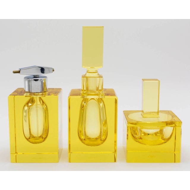 An Art Deco style Moser 3 piece cut citrine glass perfume vanity set comprised of a large bottle with stopper, a medium...